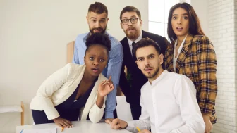 Huddled team with surprised looks on their faces